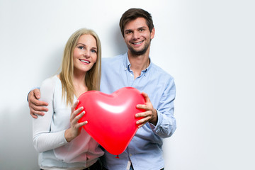 Young couple smiling and holding a heart