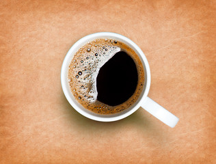 Fresh black coffee in a white cup on paper texture