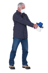 Man wearing a mask using a pressure sprayer