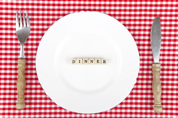Dinner-lettering on white plate with nostalgic cutlery
