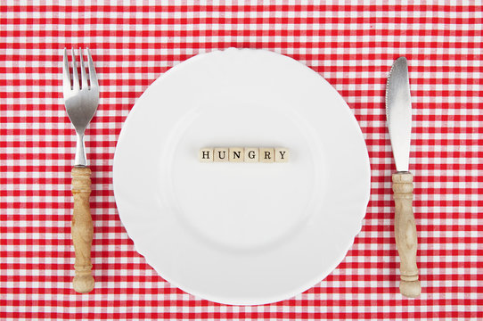 Hungry-lettering on white plate with nostalgic cutlery