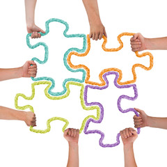 Hands holding colorful puzzle pieces