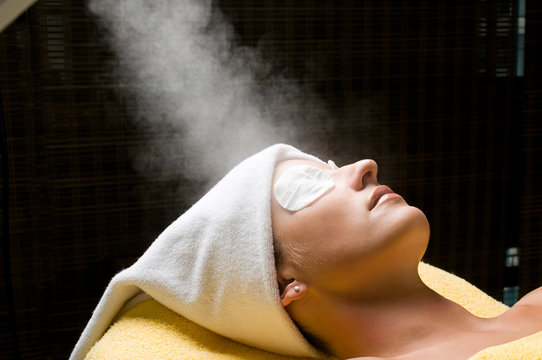 Relaxing during a facial steam treatment at  beauty spa