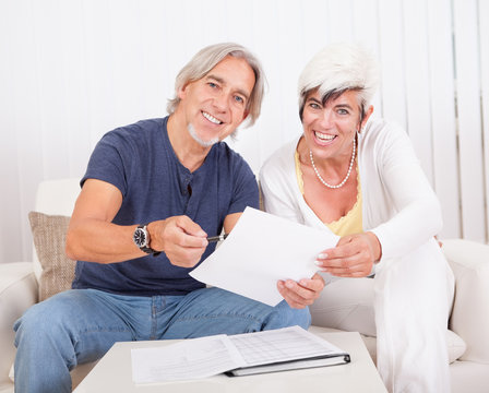 Excited middle-aged couple reading document