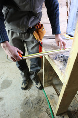Carpenter measuring plank of wood