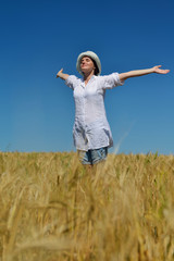 young woman in wheat field at summer