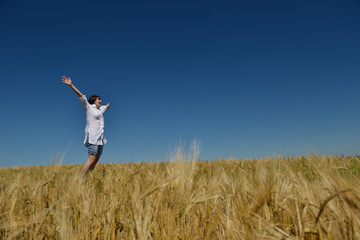 Naklejka na ściany i meble young woman in wheat field at summer