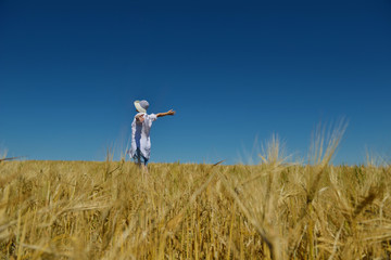 young woman in wheat field at summer