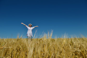 young woman in wheat field at summer