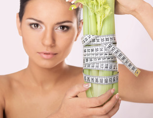 A woman measuring a vegetable with a measure tape