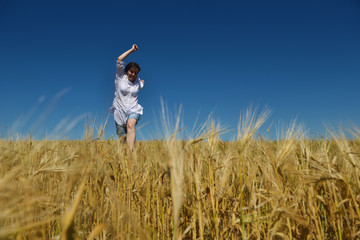 young woman in wheat field at summer