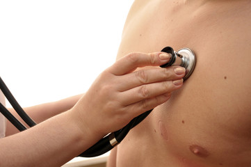 Рука врача со стетоскопом на груди молодого мужчины