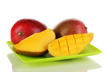 Ripe appetizing mango on green plate isolated on white