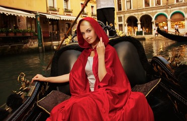 Beautiful woman in red cloak riding on gondola - obrazy, fototapety, plakaty