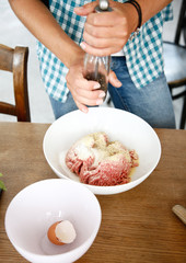 junge Frau würzt Hackfleisch