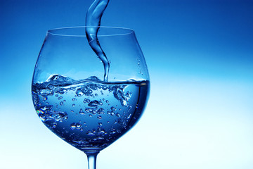 Pouring water into glass with small twister effect