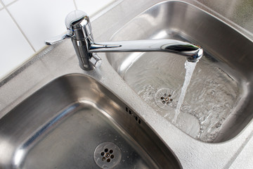 Water flowing from the faucet to the washbasin