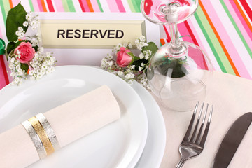 Table setting with reserved card in restaurant