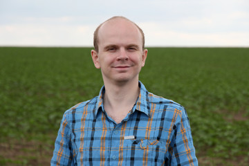 Young farmer standing near field