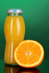 Delicious orange juice in a bottle and orange next to it