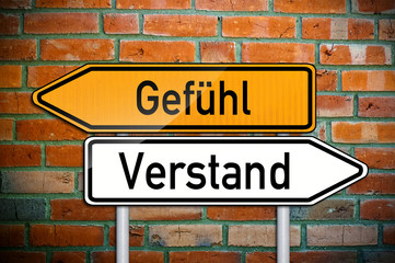 Wegweiser auf Ziegelsteinwand mit Gefühl und Verstand