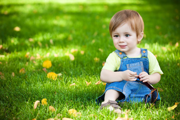 happy baby resting on the green grass. picnic