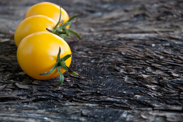 yellow tomatoes on a wooden background