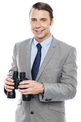 Fototapeta premium Smiling male consultant holding binoculars