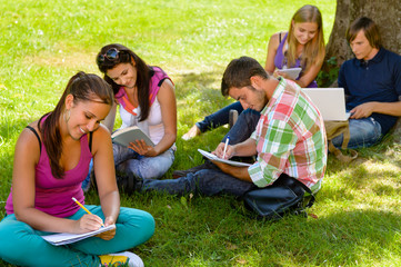 Fototapeta na wymiar Uczniowie siedzą w parku nauki pisania czytania