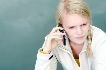 junge blonde Frau telefoniert mit ihrem Smartphone