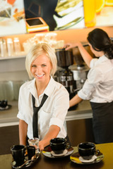 Waitress serving coffee cups making espresso woman