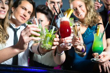 People in club or bar drinking cocktails