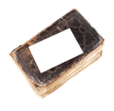 carte blanche déposée sur un vieux livre en cuir usé