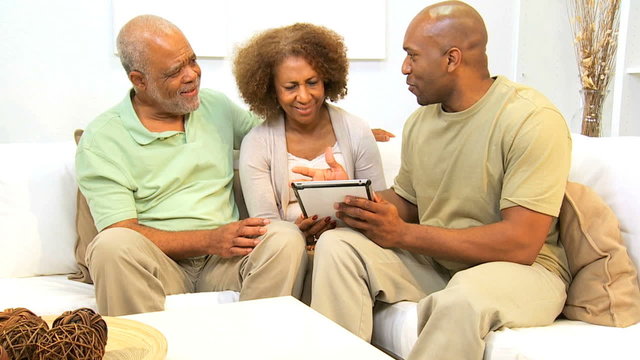 Ethnic Son and Senior Parents Using Wireless Tablet