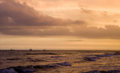 exotic sky over sea at sunset. Increasing waves reflects clouds