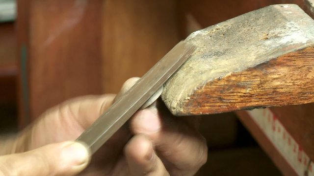 Goldschmied feilt Ring