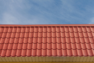 View of red roof tiles and sky on the background.