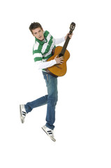 casual young man jumping with guitar