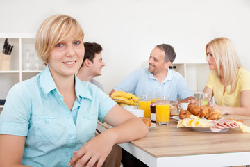 Obraz na płótnie Canvas Teenage girl and family at breakfast