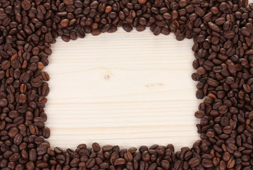 Frame of coffee beans on wooden background
