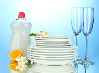 empty clean plates and glasses with dishwashing liquid and