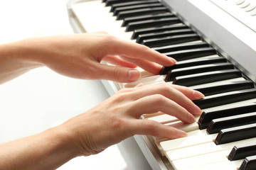 hands of woman playing synthesizer