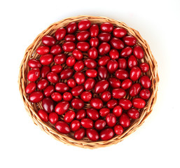 fresh cornel berries on wicker mat isolated on white