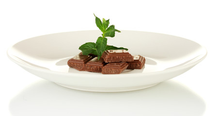 Pieces of chocolate and mint on the plate isolated on white