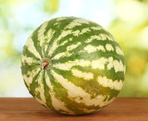 Ripe watermelon on green background close-up