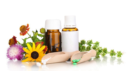 medicine bottles with tablets and flowers isolated on white