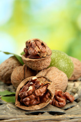 walnuts with green leaves in garden, on green background