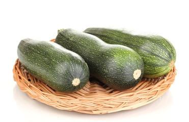 Fresh zucchini on wicker mat isolated on white