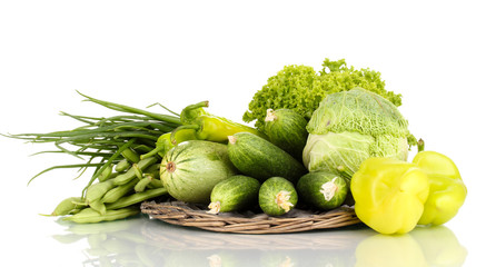 fresh green vegetables on wicker mat isolated on white