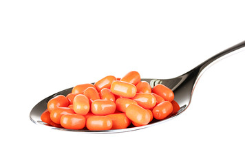 colorful pills on spoon on white background close-up